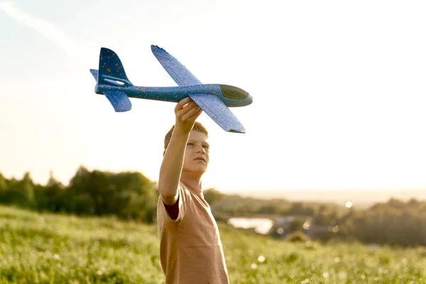 クローズアップの生姜男の子遊びおもちゃ飛行機でザ草原 — ストック写真