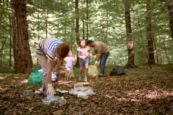 Ginger Jongen Schoonmaken Bos Van Vuilnis Met Familie — Stockfoto