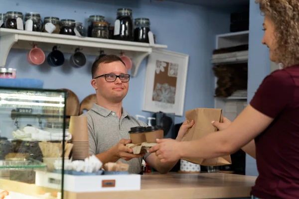 Biały Mężczyzna Zespołem Downa Dający Kawę Kobiecie Klientce — Zdjęcie stockowe