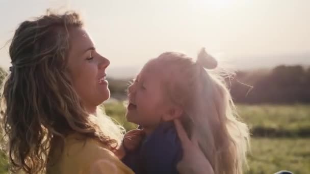 小さな娘と一緒に牧草地と結合に座ってお母さん 4KでRedヘリウムカメラで撮影 — ストック動画
