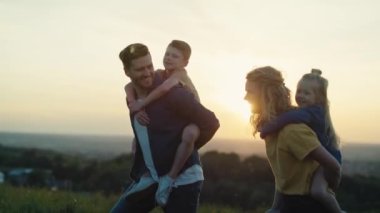 Yazın çayırda yürüyen çocuklu ebeveynler. 4K 'da kırmızı helyum kamerayla çekildi.. 