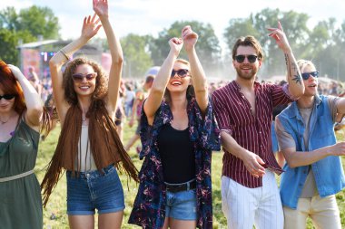 Bir grup beyaz genç müzik festivalinde dans ediyor. 