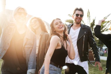 Bir grup beyaz genç müzik festivalinde dans ediyor. 