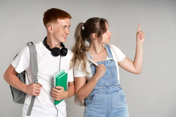 Two Young Students Showing Empty Grey Wall — Foto Stock