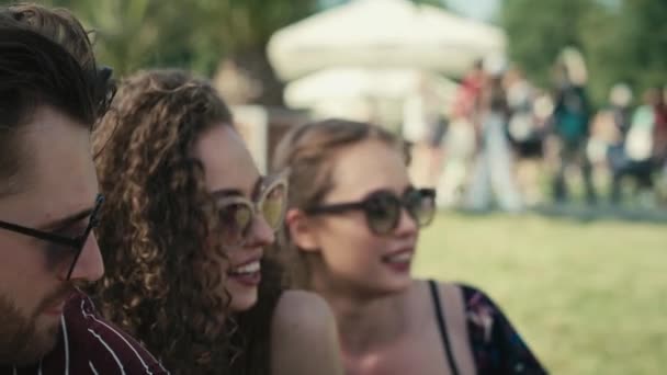 Bir Grup Arkadaş Müzik Festivalinde Çimlerin Üzerinde Birlikte Oturuyorlar Kırmızı — Stok video