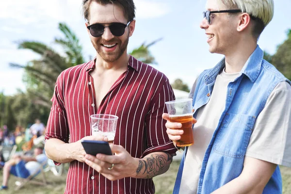 Two caucasian friends talking together on music festival