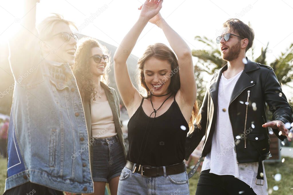 Group of young caucasian friends dancing and  having fun on music festival