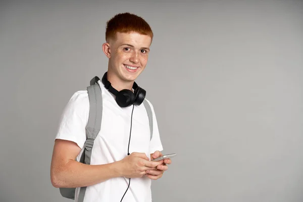 Ginger Male Student Using Mobile Phone Grey Background — Foto de Stock