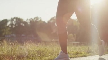 Woman exercising at the park in summer day. Shot with RED helium camera in 8K.  