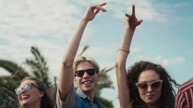 Young caucasian friends dancing on music festival with hands up. Shot with RED helium camera in 8K. 
