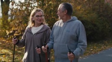 Parkta yürüyen Kafkas kıdemli çift. 4K 'da kırmızı helyum kamerayla çekildi.   