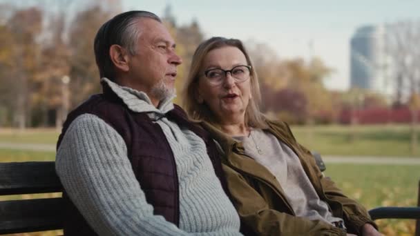 Caucasian Senior Couple Sitting Bench Park Embracing Shot Red Helium — стокове відео