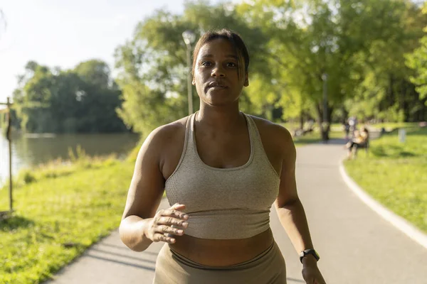 Focus African American woman running at the park