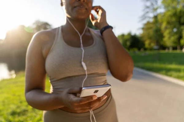 African American Woman Using Mobile Phone Earphones Exercising Park Summer — Stock fotografie