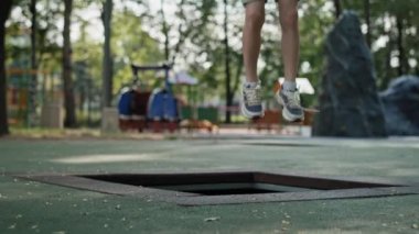 05 Caucasian ginger boy jumping on trampoline at playground. Shot with RED helium camera in 8K.   