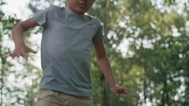 Caucasian boy jumping on trampoline at playground. Shot with RED helium camera in 8K.  