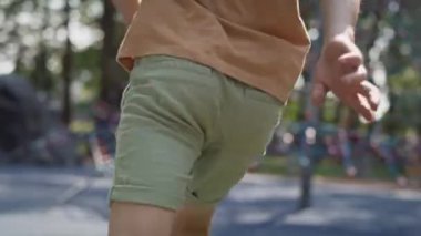 Caucasian boy have fun at the playground in summer day. Shot with RED helium camera in 8K.   