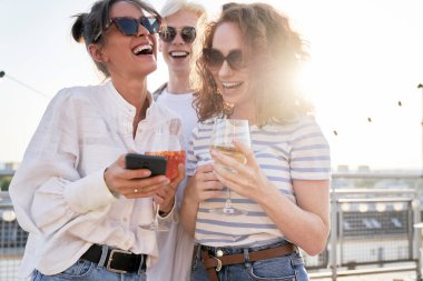 Group of friends looking at mobile phone at the party