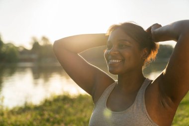 Smiling African American preparing for workout at the park in summer day
