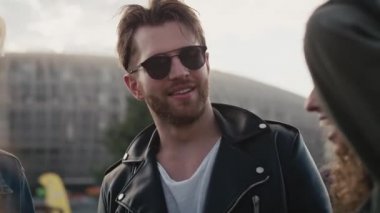 Bir grup beyaz arkadaş sohbet ediyor ve müzik festivalinde eğleniyorlar. 8K 'da kırmızı helyum kamerayla çekildi.. 