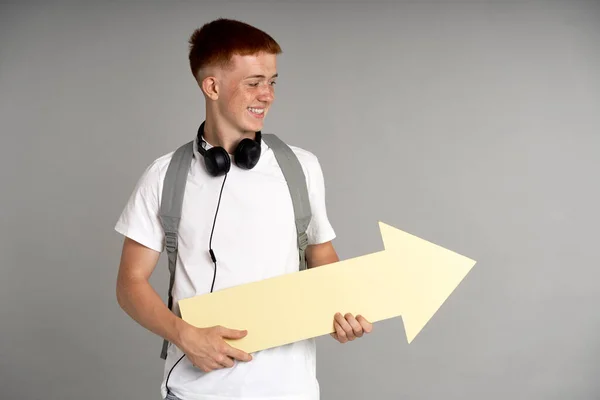 Redhead Boy Schoolbag Holding Big Arrow Sign Looking — Stockfoto