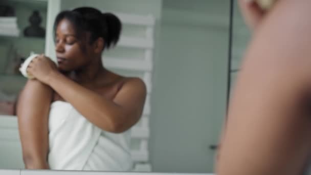 African American Woman Scrubbing Skin Domestic Bathroom Reflection Mirror Shot — Vídeo de Stock