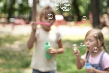 Close up of soap bubbles blowing by girls