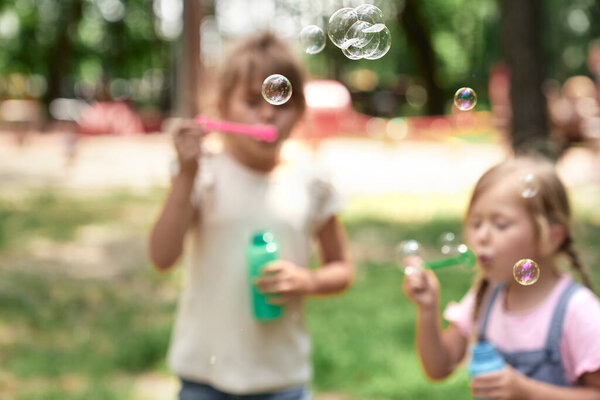 Close up of soap bubbles blowing by girls
