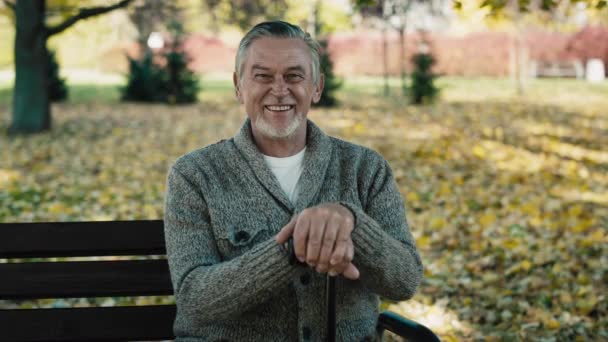 Portrait Senior Man Sitting Bench Park Autumn Shot Red Helium — Vídeo de Stock