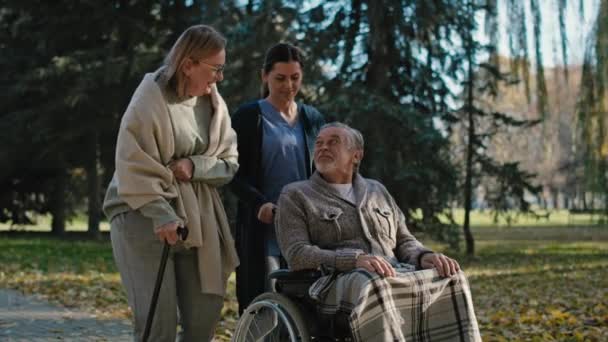 Female Nurse Walking Senior Patients Park Shot Red Helium Camera — Vídeos de Stock