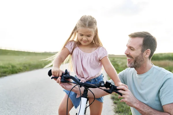 Father Teaching His Little Daughter How Ride Bike — Stock fotografie