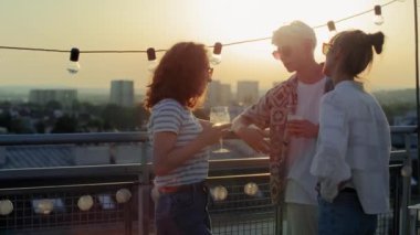 Young adult friends talking together at the party during the sunset. Shot with RED helium camera in 8K. 