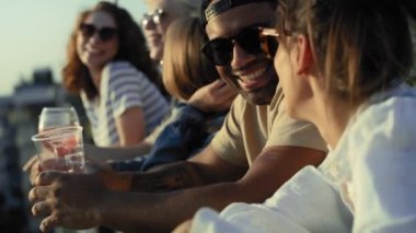 Group of multi ethnicity friends talking together at the party in top of the roof. Shot with RED helium camera in 8K. 