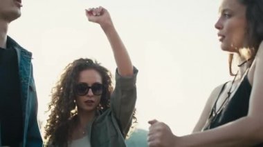 Kafkasyalı genç arkadaşlar müzik festivalinde elleri havada dans ediyorlar. 8K 'da kırmızı helyum kamerayla çekildi.. 