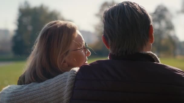 Senior Caucasian Couple Sitting Embracing Together Park Shot Red Helium — Stockvideo