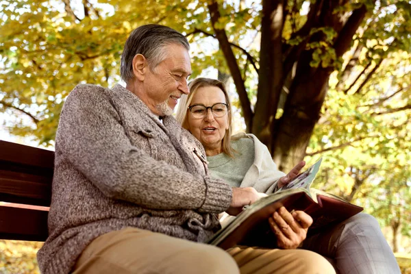 Senior Couple Sitting Bench Park Looking Old Photos — 图库照片