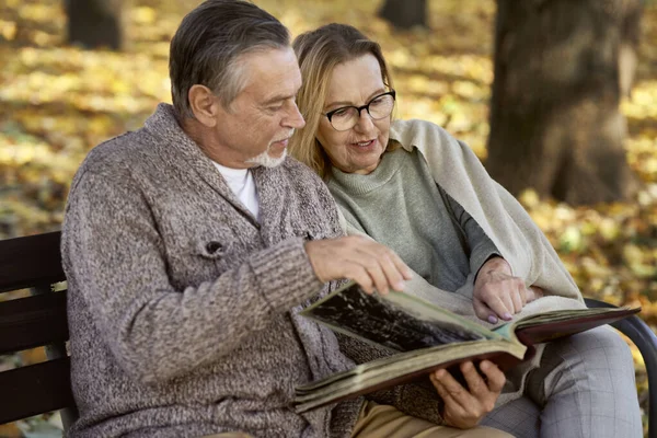 Senior Couple Sitting Bench Park Looking Old Photos — Foto Stock