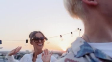 Caucasian friends dancing at the party in top of the roof. Shot with RED helium camera in 8K. 