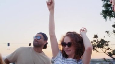Group of multi ethnicity friends dancing at the party in top of the roof. Shot with RED helium camera in 8K.  
