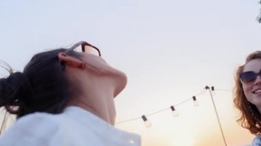 Friends dancing together at the rooftop party during the sunset. Shot with RED helium camera in 8K.  