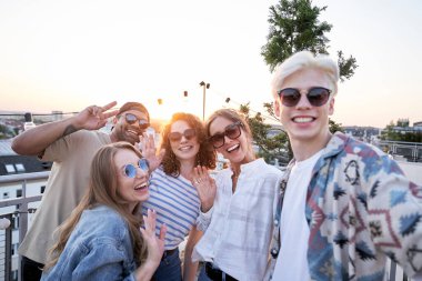Group of friends have video call from rooftop party