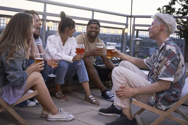 Group of friends at the rooftop party drinking a cocktails