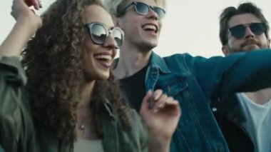 Young caucasian friends dancing on music festival with hands up and having fun. Shot with RED helium camera in 8K. 