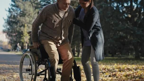 Female Nurse Helping Disability Man Helps Get Wheelchair Shot Red — Vídeos de Stock