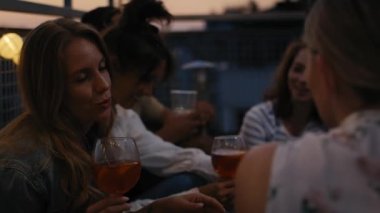 Caucasian girls talking together at evening party in top of the roof. Shot with RED helium camera in 8K.  