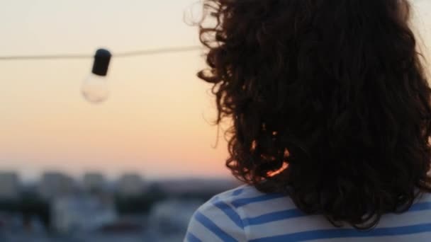 Τζίντζερ Γυναίκα Στέκεται Και Κοιτάζει Ηλιοβασίλεμα Στην Ταράτσα Της Πόλης — Αρχείο Βίντεο
