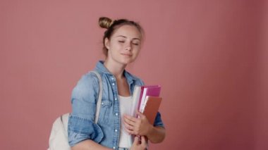 Portrait of caucasian teenage girl carrying backpack and books. Shot with RED helium camera in 8K.    