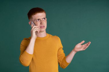 Ginger male student holding and showing mobile phone