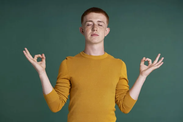 Caucasian Teenage Boy Meditating Eyes Closed Green Background — Photo