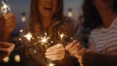 Group friends celebrating together at the rooftop with sparkles. Shot with RED helium camera in 8K.  